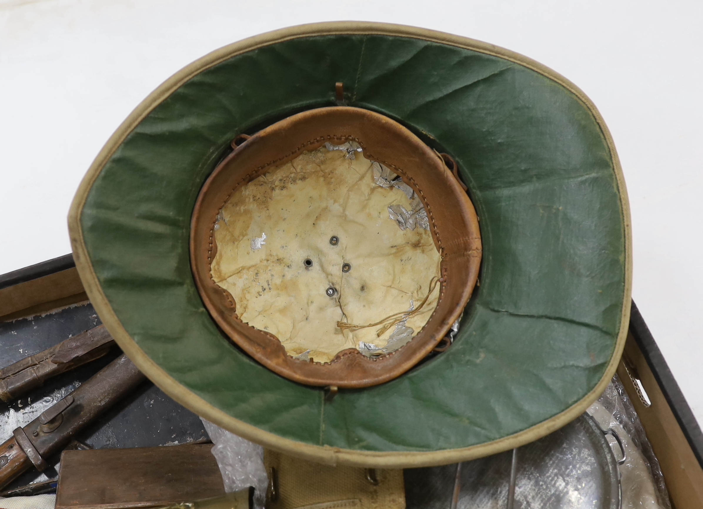 A collection of militaria including; a pith helmet, a T.G. Co. Ltd. Mk.III compass, a cased protractor, a Union flag, a trench art shell casing, a bayonet, an Indian knife, a mess plate with ERII cypher, etc.